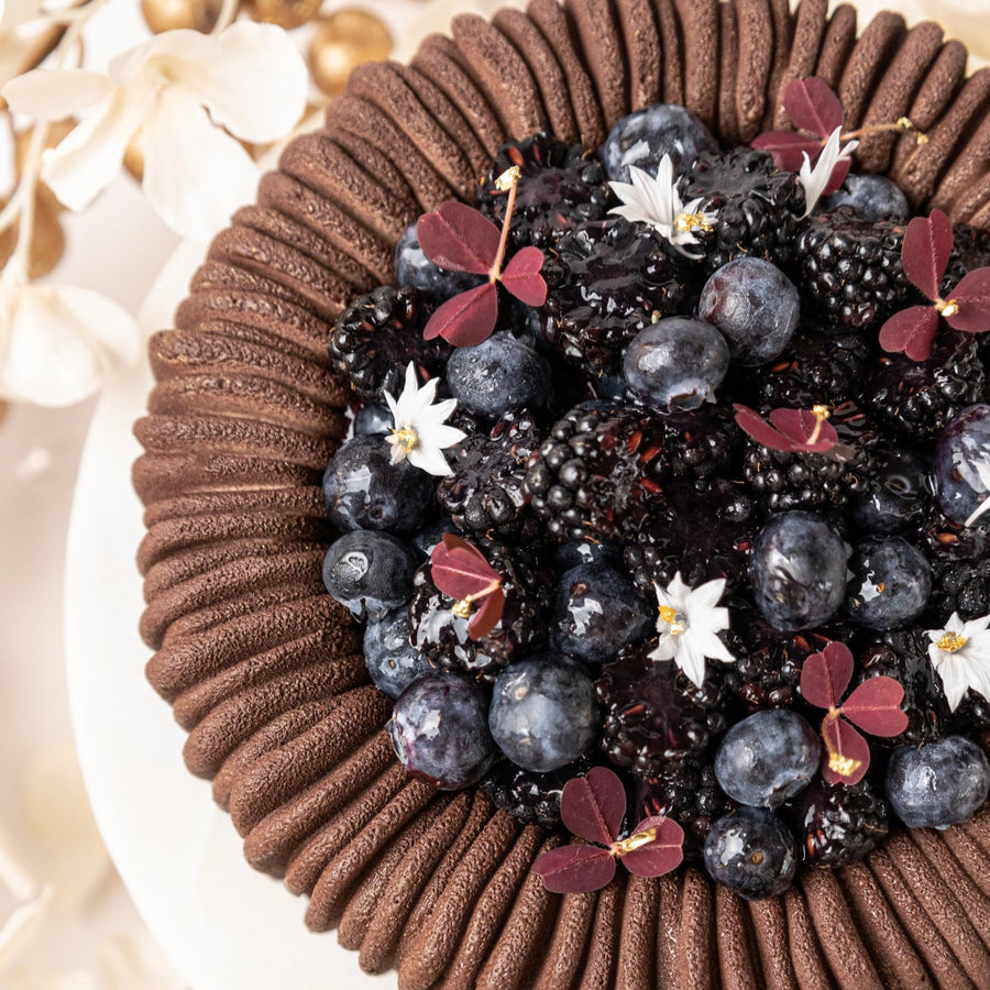 Chocolate cake with blueberries and flowers on a decorative background